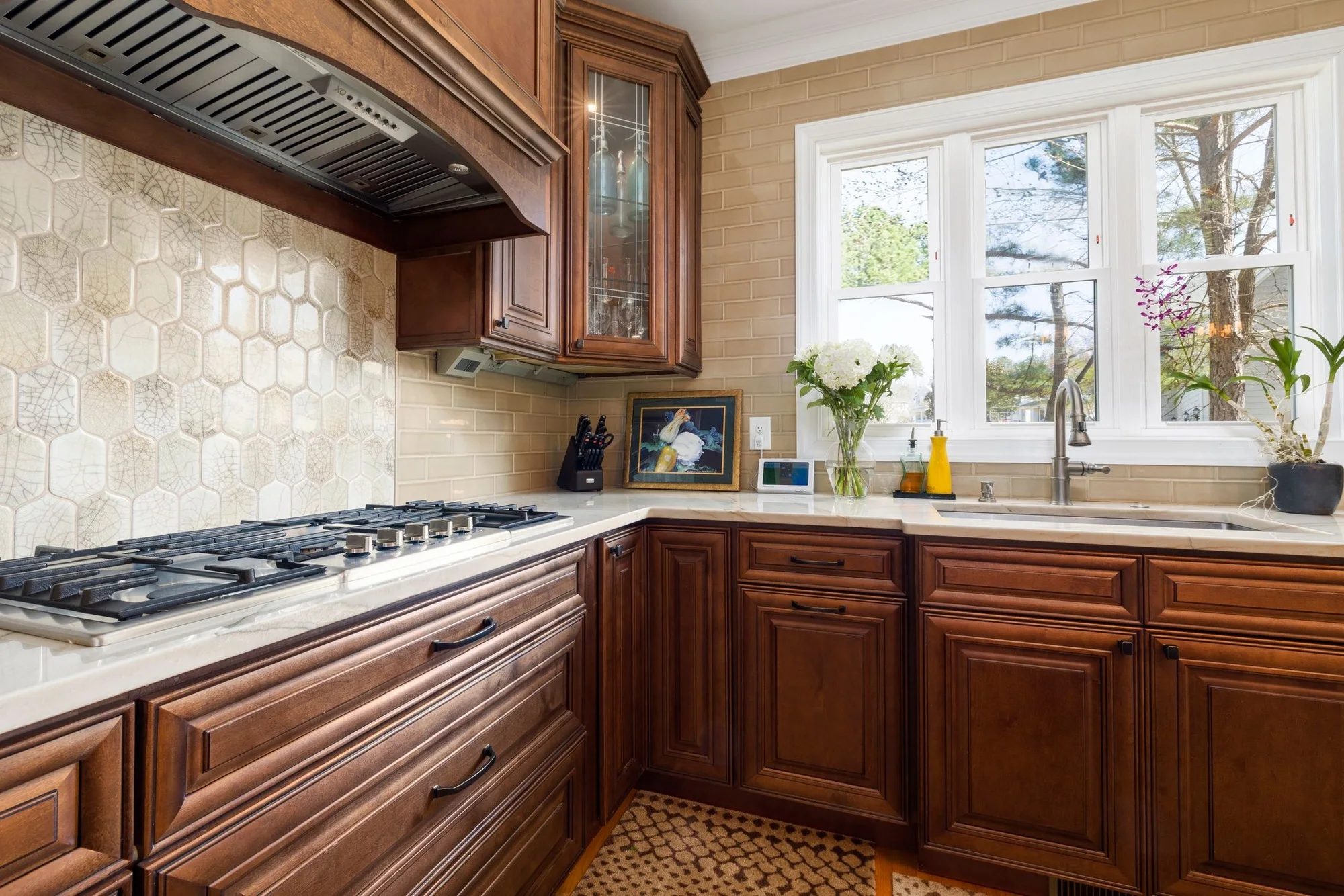 Warm traditional kitchen with wood cabinets and a garden window