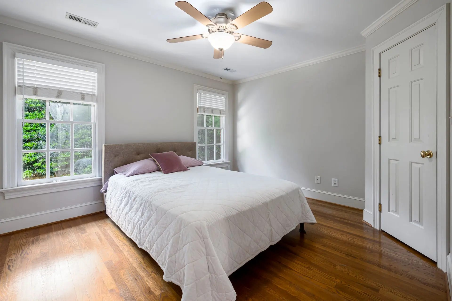 Freshly made bed with crisp white linens in a bright bedroom